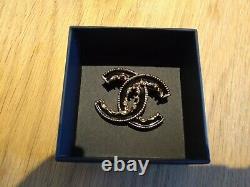 CHANEL Limited Edition! Black enamel and gold metal CC scroll brooch, In Box